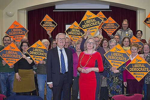 Lord Dick Newby with Jenny Wilkinson in front of enthusiastic Lib Dems waving Lib Dem diamonds