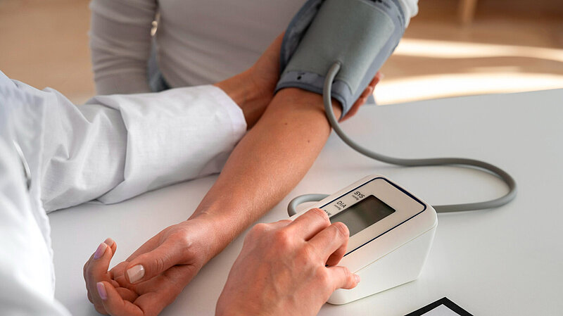 Photo shows patient having their blood pressure taken.