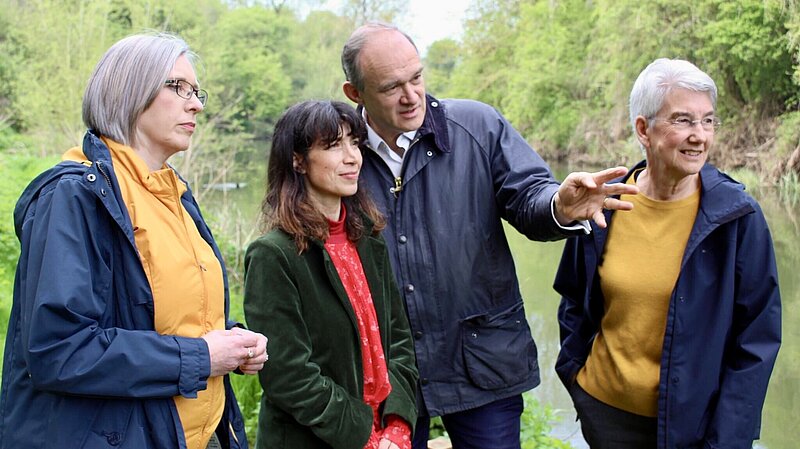 Jenny Wilkinson, Manuela Perteghella, Ed Davey and Susan Junes with trees and a river behind them