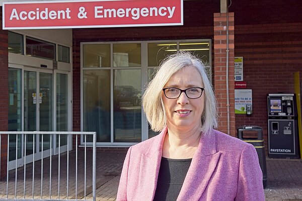 Jenny Wilkinson in front of Accident and Emergency Sign at a hospital
